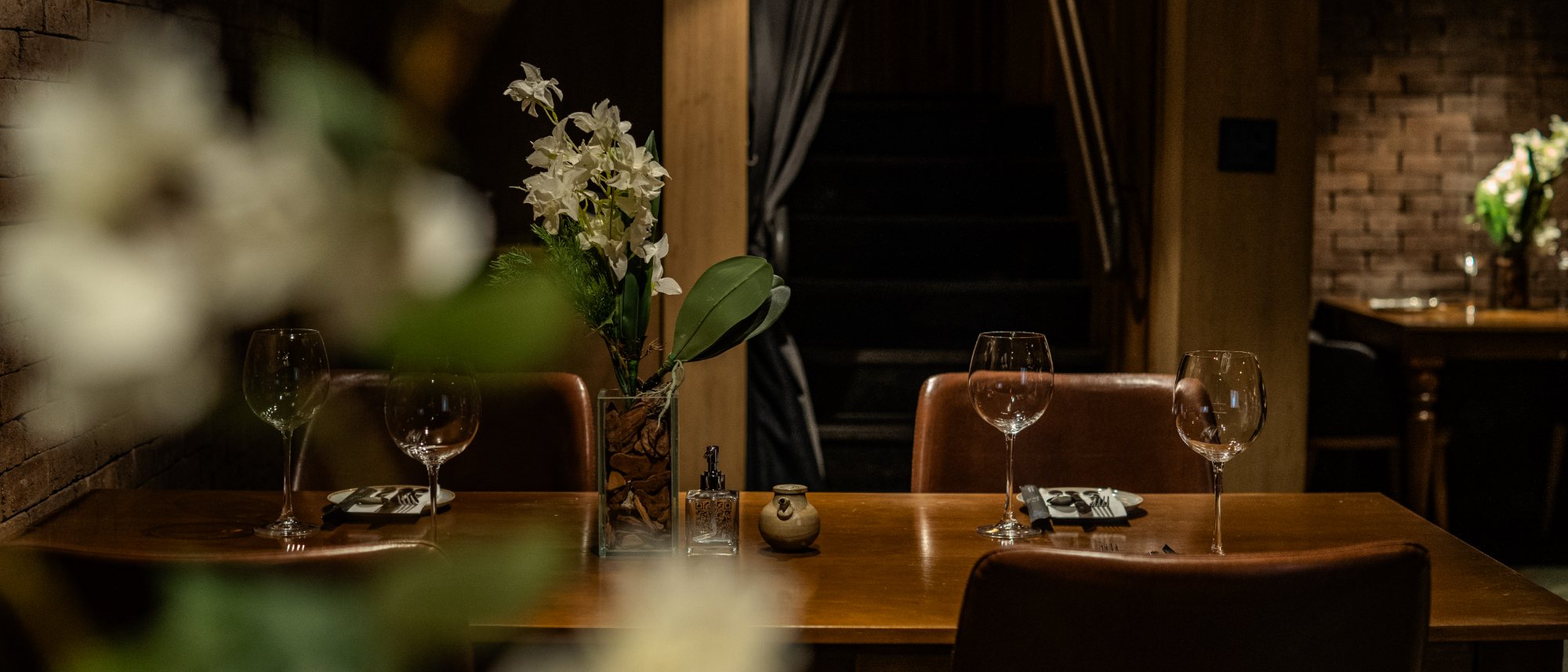 A sala da Cave: tijolo aparente, mesa posta e a adega ao fundo
