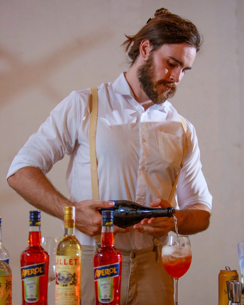 Bartender servindo, convidados no bar