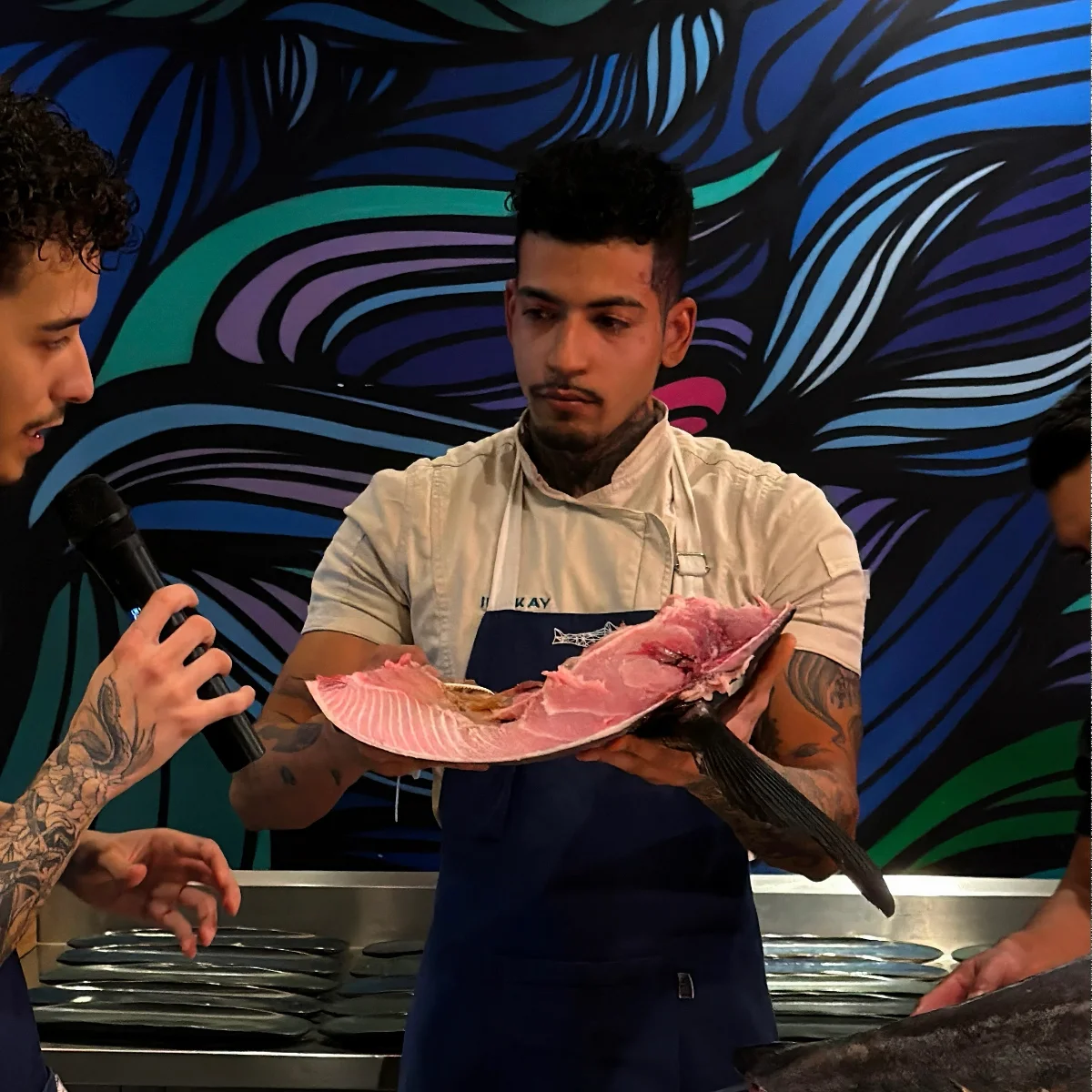 A faca no meio do corte, mãos do chef em foco